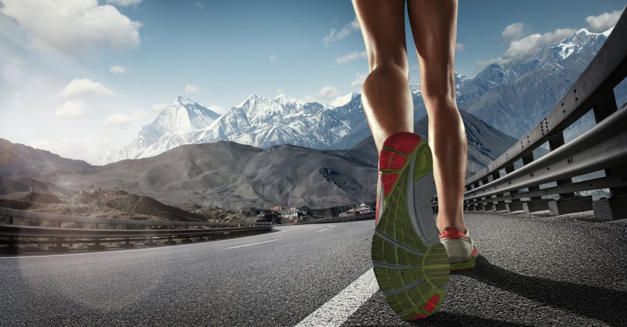 Sports background. Runner feet running on the road. Closeup on shoe